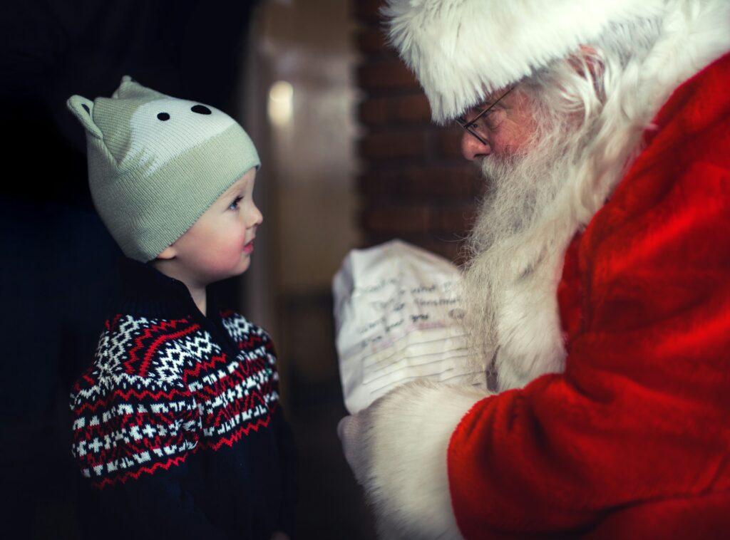 Father Christmas hands a present to a child