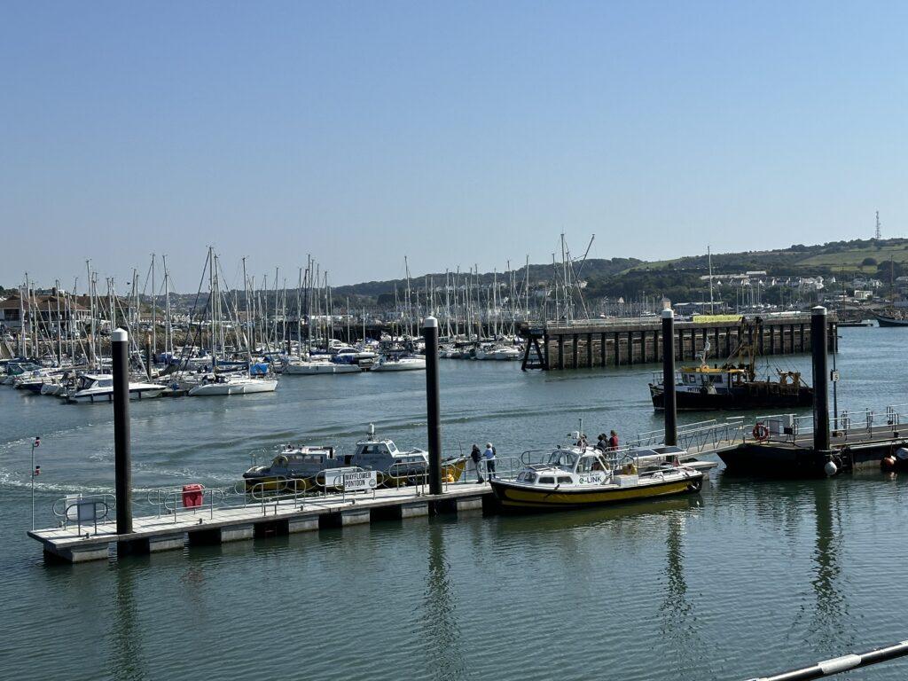 A view out across Plymouth Sound, there are boats docked at the Barbican Landing Stage.