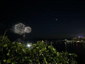 Golden fireworks sparkle above the Plymouth Sound and reflect on the water below
