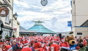 A group of people dressed as Santa gather on Plymouth's Barbican.