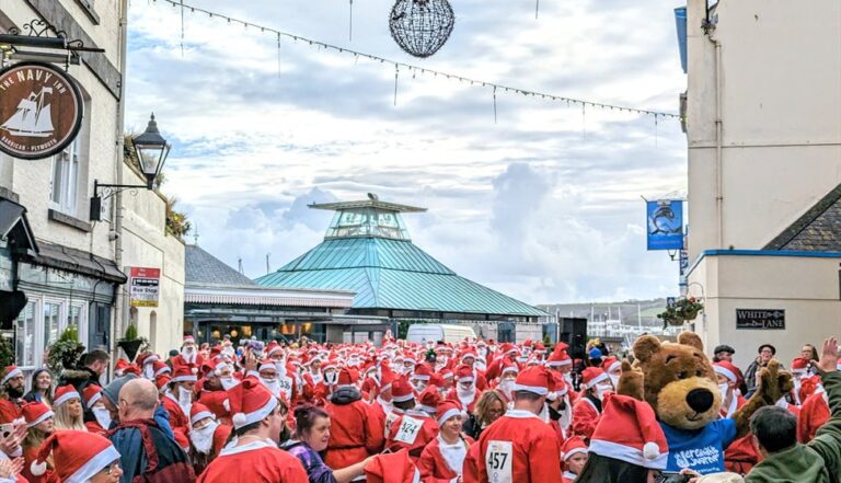 A group of people dressed as Santa gather on Plymouth's Barbican.